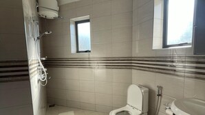 Une salle de bain comprenant des toilettes, un lavabo, une douche et une fenêtre.