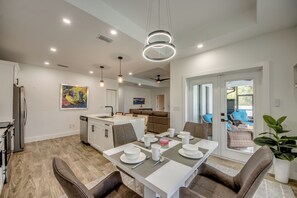 A modern kitchen with a dining area, a ceiling fan, and a large window. - Villa Sunnyside Up- Your Peaceful Getaway in NW Cape Coral (Cape Coral)