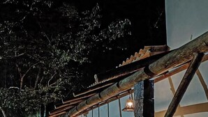 Un edificio con un porche, una hamaca y una silla.