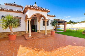 A building with a tiled roof, a covered patio area, and potted plants. - Sara Sol in Frigiliana (Frigiliana)