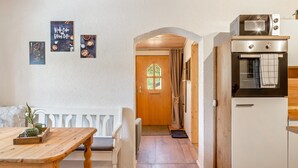 A cozy kitchen with a wooden bench, a white refrigerator, and a microwave. - Apartment 'Fewo Edelweiss' with Private Sun Terrace and Wi-Fi (Breitenberg)