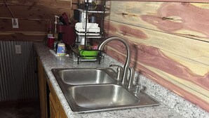 Eine Küche mit Granitarbeitsplatten, Edelstahlspülen, Holzschränken und einer eingebauten Dunstabzugshaube.