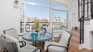 A balcony with a glass table, wicker chairs, and a view of the city. - Fidalsa Summer Breeze (Orihuela)
