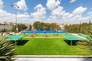 Ein Innenhof mit Tischtennisplatte, kleinem Pool und Fitnessgeräten.