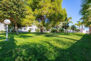 A well-maintained grassy area with trees and a lamp post. - Fidalsa Luxurious Villa Salinas and Sea (Santa Pola)