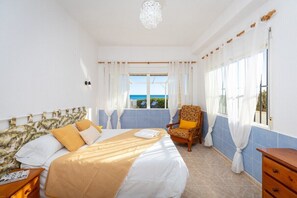 Une chambre d’hôtel avec un lit, une chaise, une table de chevet et une fenêtre donnant sur un paysage agréable.