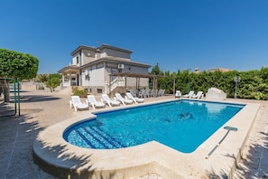 A swimming pool with lounge chairs, a pergola, and a building in the background. - Fidalsa Grand White House (Mutxamel)