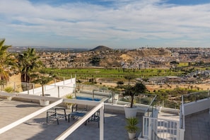 A rooftop terrace with a pool, potted plants, and a view of a cityscape. - Fidalsa Golf & Beach (Rojales)