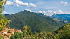 Un paisaje montañoso con un pueblo, casas y una piscina.