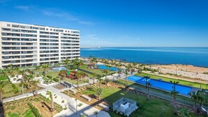 A hotel with multiple floors, outdoor swimming pools, and a beach view. - Fidalsa Paradise Sea Punta Prima (Torrevieja)
