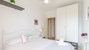A bedroom with a bed, a nightstand, a desk, a wardrobe, and a ceiling fan. - Beach Haven by Fidalsa (Guardamar del Segura)