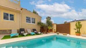 A swimming pool with lounge chairs and a small garden area. - Fidalsa Coastal Soul (Torrevieja)