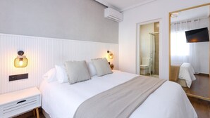 A neatly arranged bedroom with a large bed, bedside tables, a mirror, and a television. - The Big Chill by Fidalsa (Rojales)