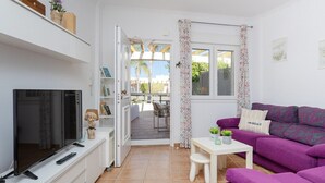A compact living space with a TV, sofa, and a dining area. - Happiness Corner by Fidalsa (Pilar de la Horadada)