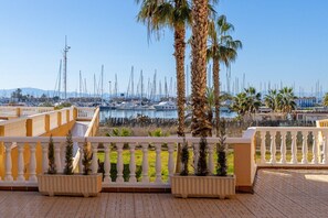 Ein Yachthafen mit Booten, Palmen und einem Balkon mit Pflanzgefäßen.