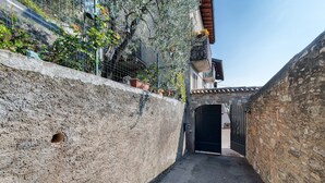 A narrow alleyway with a stone wall on one side and a building entrance on the other.