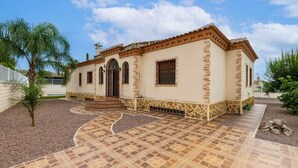 A two-story building with a tiled patio, arched windows, and a small garden. - Mountain Beautiful by Fidalsa (Busot)