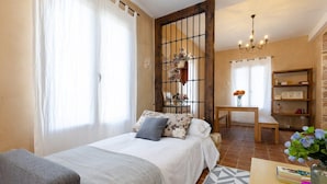A bedroom with a bed, a desk, a chair, a bookshelf, and a window with curtains. - Historical Palms by Fidalsa (Elche)