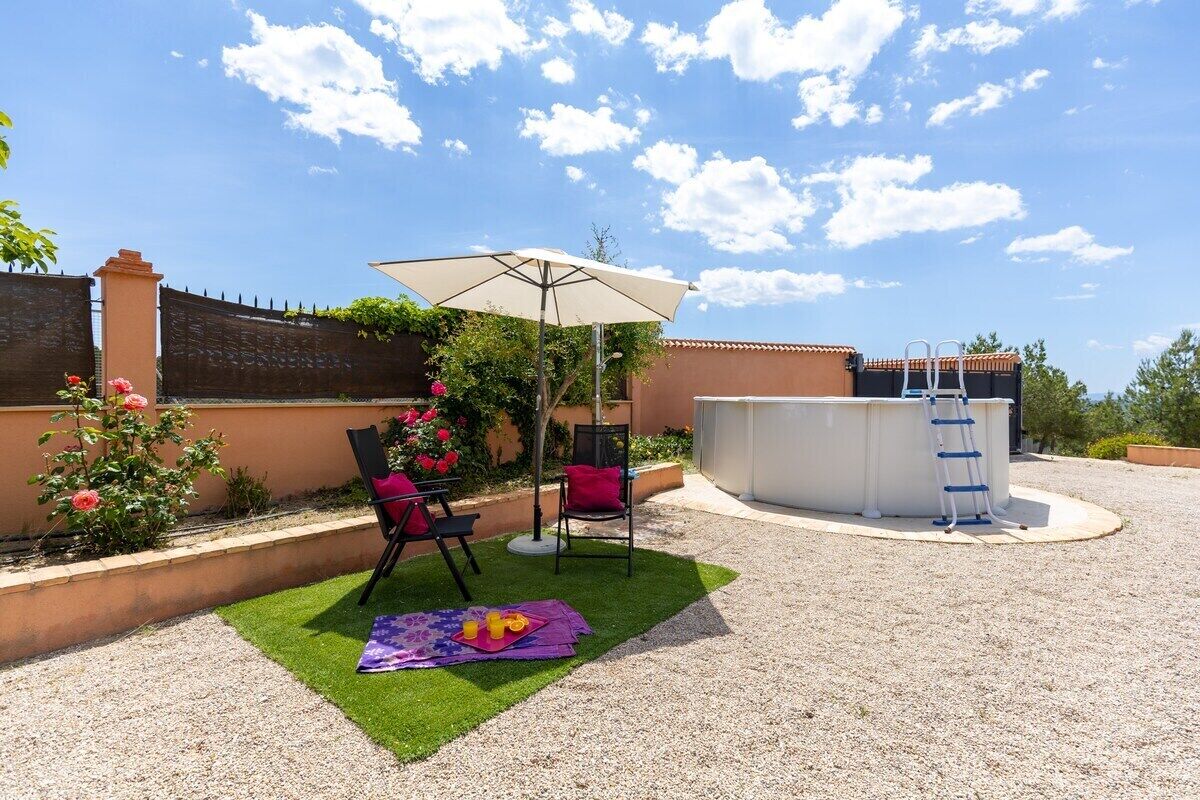 An outdoor patio with a pool table, chairs, and a table with food.
