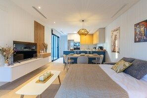 Ein modernes Wohnzimmer mit einer Couch, Fernseher und Essbereich.