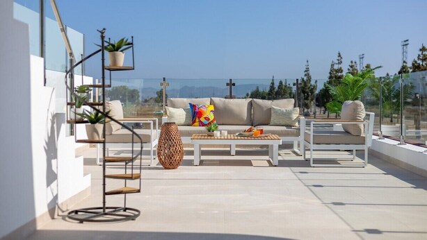 A rooftop terrace with a sofa, coffee table, and chairs, surrounded by potted plants and a decorative vase. - Dreamscape Villa by Fidalsa (Los Alcazares)