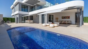 A modern two-story house with a swimming pool, outdoor seating, and a bike parked outside. - Dreamscape Villa by Fidalsa (Los Alcazares)