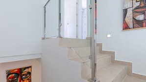 A modern staircase with glass railings and beige steps. - Dreamscape Villa by Fidalsa (Los Alcazares)