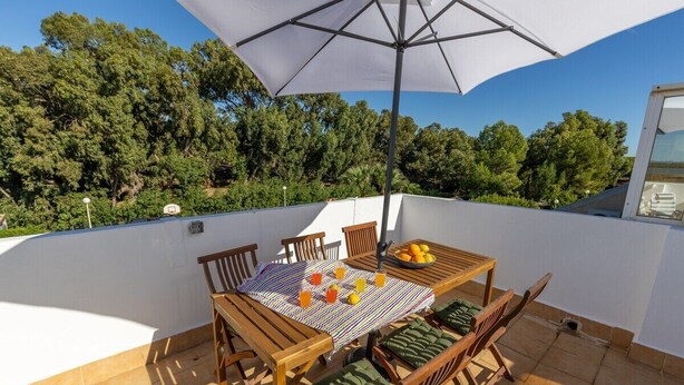 A terrace with a table, chairs, and an umbrella. - Coral Seashell by Fidalsa (Guardamar del Segura)