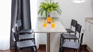 A dining area with a table, chairs, a potted plant, and a fruit bowl. - Coral Seashell by Fidalsa (Guardamar del Segura)