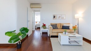 A living room with a sofa, coffee table, and a potted plant. - Coral Seashell by Fidalsa (Guardamar del Segura)