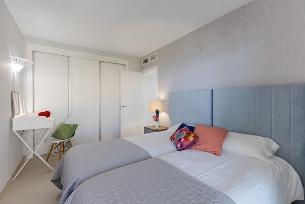 A hotel room with a large bed, a desk, and a chair. - Paradise Views by Fidalsa (Torrevieja)
