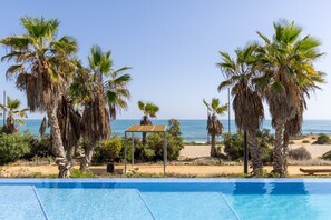 A pool with a view of the beach and palm trees. - Paradise Views by Fidalsa (Torrevieja)