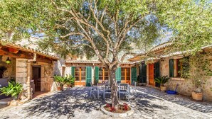 A courtyard with a tree, stone walls, and outdoor seating. - Villa 'Martorell' with Private Pool, Wi-Fi and Air Conditioning (Illes Balears)