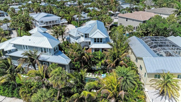 A residential area with houses surrounded by palm trees and a clear view of the ocean. - Pineapple Paradise-Pool Home 2Blocks to the Beach-By Island Real Estate (Holmes Beach)
