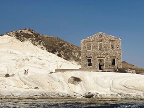 A stone building with a simple, rustic design, situated on a white, rocky hillside with a clear blue sky above. - Akragas home 2 with city view (Agrigento)