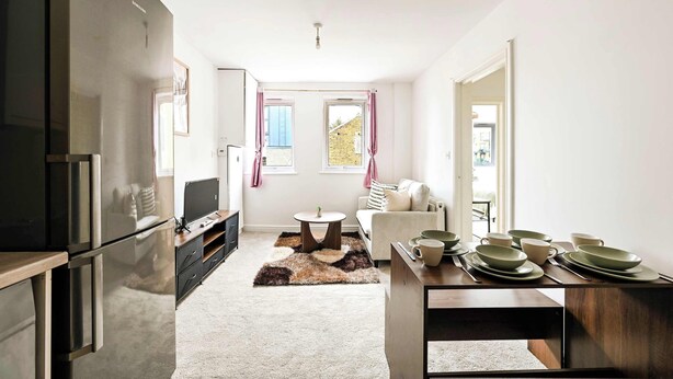 A compact kitchen with modern appliances, a dining area with a table set for four, and a cozy living space with a sofa and a view through a window. - Chic 1BR West Ealing - 15m Heathrow - 20m City (London)