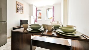 A kitchen with a dark wooden countertop, a refrigerator, and a window with pink curtains. - Chic 1BR West Ealing - 15m Heathrow - 20m City (London)