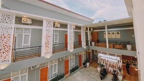Un atrium d’hôtel à plusieurs niveaux, doté de balcons, de panneaux décoratifs et d’un espace central ouvert.