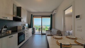Eine moderne Küche mit Essbereich, Blick ins Freie und einem Balkon.