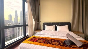 A hotel room with a large window, a bed with white bedding, a headboard, and a view of a cityscape. - THE MANOR CLASIC SUITES BY BUKIT BINTANG (Kuala Lumpur)
