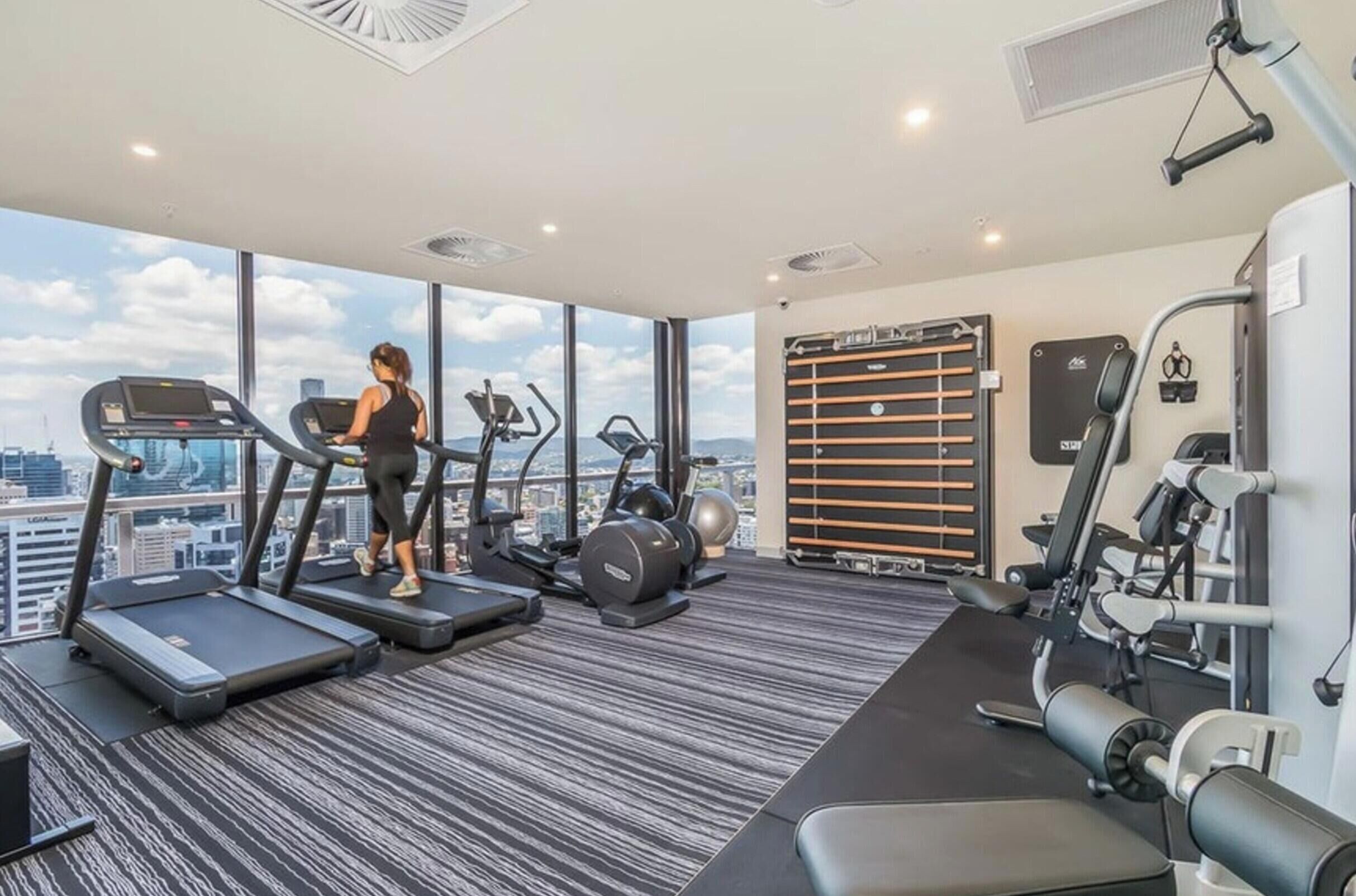 A gym with treadmills, elliptical machines, and weight equipment.