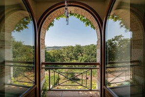 Habitació amb una finestra gran d'arc que ofereix vistes a un paisatge exuberant.