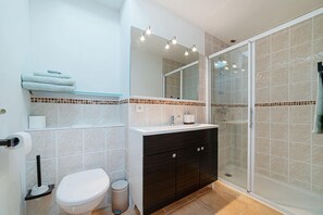 A bathroom with a toilet, sink, mirror, and shower. - Authentic, modern house, pets welcome, a real haven of peace. (Cancon)