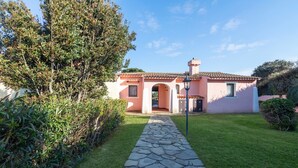 A house with a stone pathway leading to the entrance, surrounded by greenery. - Villa 'Armonia - Private Pool' with Private Pool, Wi-Fi and Air Conditioning (Punta de Su Turrione)