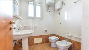 A bathroom with a sink, two toilets, a bidet, and a window. - 2 Bedroom Apartment in Rivabella di Gallipoli RB152 (Rivabella)