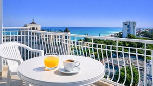Ein Balkon mit Tisch, Stuhl, Orangensaftglas und Kaffeetasse.
