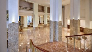 Eine großzügige Hotelhalle mit hohen Decken, mehreren Etagen und einem zentralen Atrium.