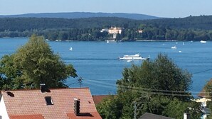 A view of a lake with boats, a building on the shore, and trees. - Apartment Hoeri with Private Garden, Terrace, and Wi-Fi (Uhldingen-Mühlhofen)
