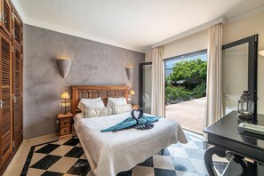 Una camera d'albergo con un letto, lampade ai comodini, una scrivania e vista all'esterno.