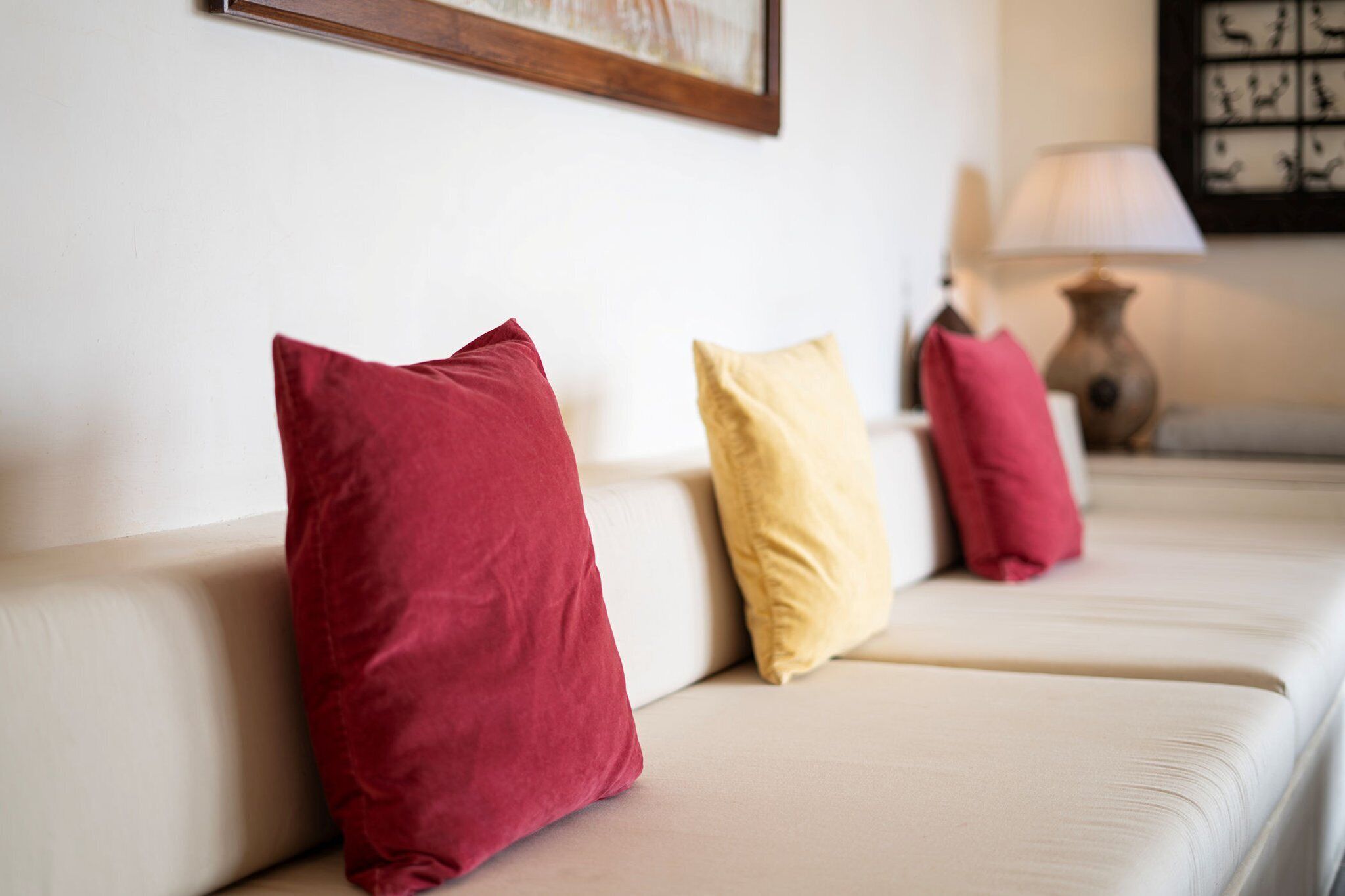 Un sofá con tres almohadas de distintos colores.